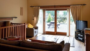 A cozy living room with a sofa, a television, and a wooden ceiling. - 2 bedroom accommodation in Dockray, near Ullswater (Dockray, near Ullswater)