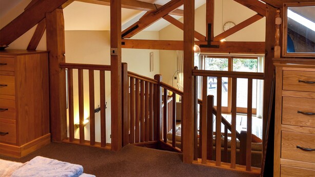 A wooden staircase with a railing, leading to an upper floor. - 2 bedroom accommodation in Dockray, near Ullswater (Dockray, near Ullswater)
