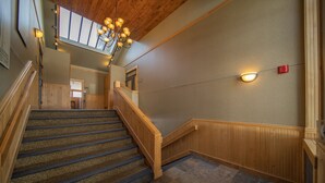 A staircase with wooden railings and a patterned carpet. - Lenawee 1741 (Keystone)