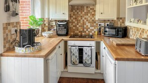A kitchen with white cabinets, a wooden countertop, a coffee maker, a microwave, and a toaster. - 2 bedroom accommodation in Stockbridge (Stockbridge)