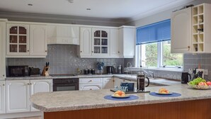 Une cuisine moderne avec des meubles blancs, un plan de travail en granit et un îlot central intégré.