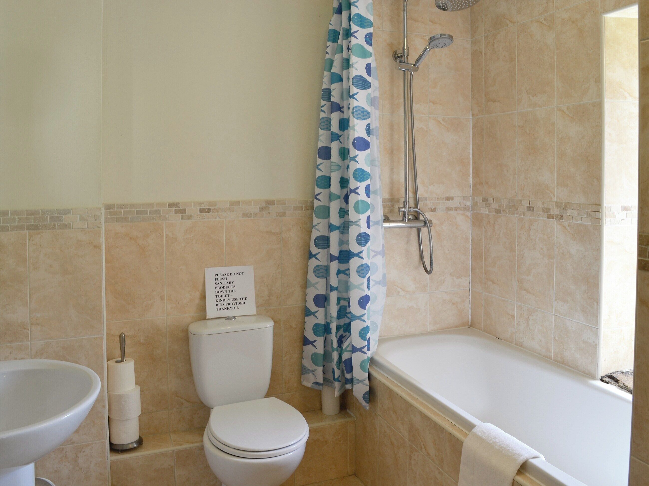 Une salle de bain avec des toilettes, un lavabo et une baignoire.