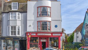 A two-story building with a ground-floor shop named 'Hastings Antiques Warehouse' and a gallery on the left. - 1 bedroom accommodation in Hastings (Hastings)