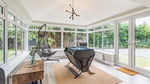 A spacious room with a pool table, a hanging chair, and a ceiling light fixture. - 3 bedroom accommodation in Llanerfyl, near Welshpool (Llanerfyl, near Welshpool)