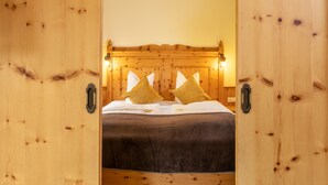 Un lit en bois avec deux oreillers et une couvre-lit sombre.