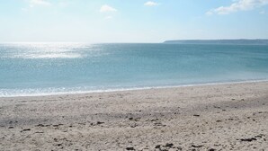Uma praia com céu claro e mar calmo.