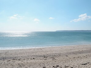 A beach with a clear sky and calm sea. - 1 bedroom accommodation in Helston, near Helston and the Lizard Peninsula (Helston, near Helston and the Lizard Peninsula)