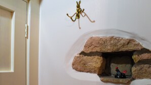 Un mur orné d’une petite niche en pierre dans laquelle se trouve une statuette.