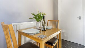 Una mesa de comedor con platos, una copa y un florero con flores.