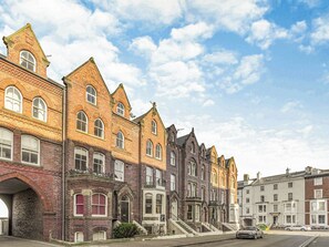 A row of historic brick buildings with arched windows and a clear sky. - Immaculate Sea View Apartment - Desirable West Cliff Location. (Whitby)