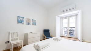 Une chambre d’hôtel avec un lit, une chaise, un bureau et un balcon offrant une vue.