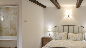 Un dormitorio con cama, mesita de noche, lámpara y una lámpara de pared.