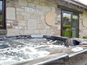 Un edificio de piedra con un jacuzzi, una brújula y un reloj en la pared.