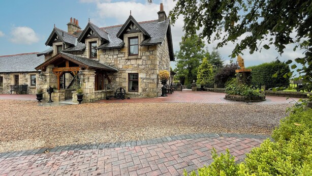 Een stenen gebouw met een bord waarop staat 'Pinnow Farm House'.