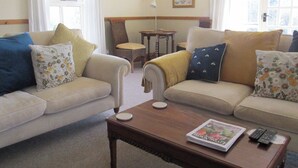 A living room with two sofas, a coffee table, and a small table with a lamp. - Robin Cottage Nr Rothbury (Weldon Bridge, near Rothbury)