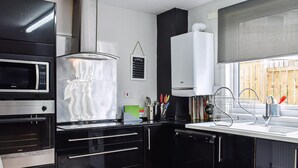Una cucina moderna con mobili neri, un forno a microonde, un fornello e un lavello.