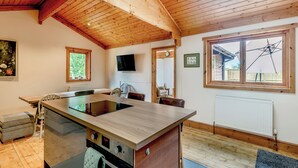 Una cocina moderna con vigas de madera, una isla grande y un horno empotrado.