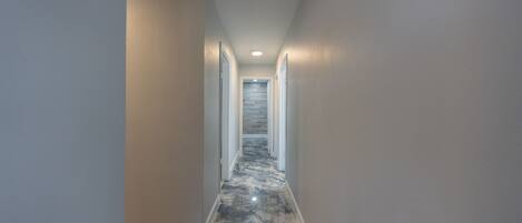 A hallway with a glossy, reflective floor and white walls.