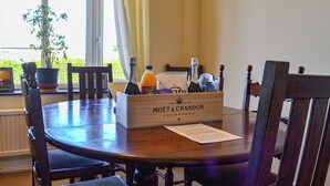A wooden dining table with a box labeled "MOËT & CHANDON CHAMPAGNE" and a bottle of orange juice. - 4 bedroom accommodation in Hunstanton (Hunstanton)