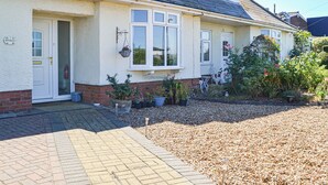 A two-story house with a front door, a small porch, and potted plants. - 4 bedroom accommodation in Hunstanton (Hunstanton)