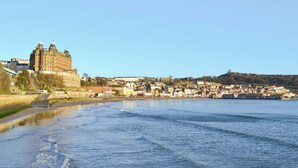 A waterfront cityscape with historic buildings and a castle-like structure. - This delightful single storey cottage offers cosy holiday accommodation. (Kirkbymoorside)