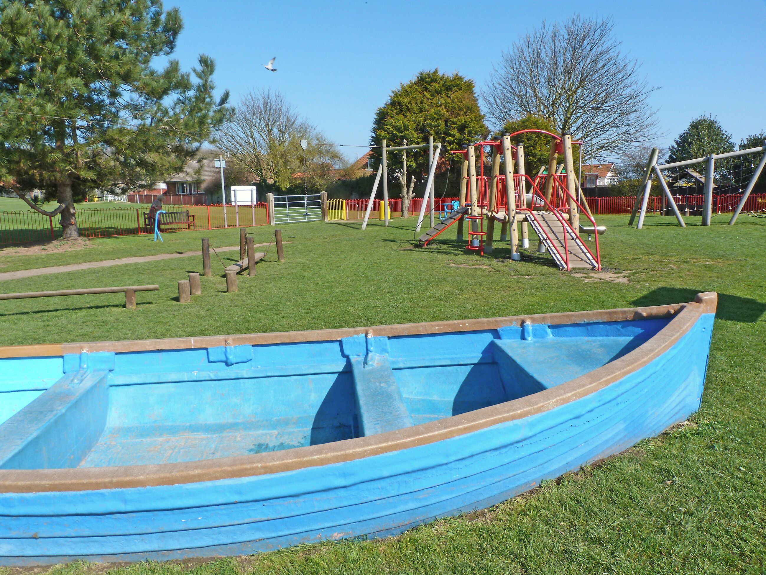 A playground with a blue slide, swings, and a climbing structure.