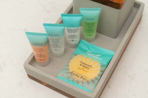 A tray with various body care products including a body bar, conditioner, lotion, and shampoo.