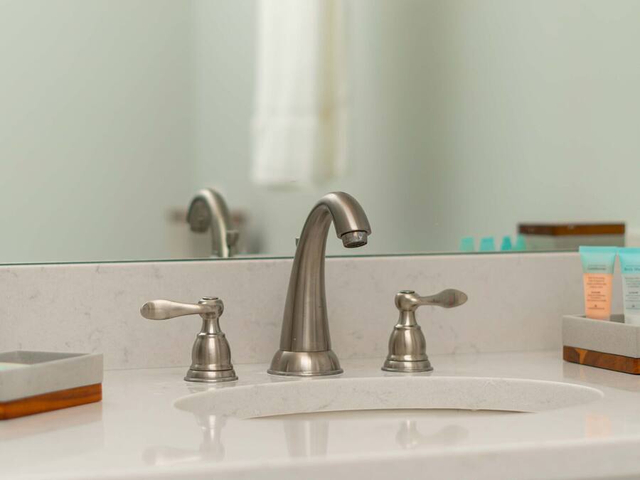 Un lavabo de salle de bain doté d’un robinet moderne, d’un distributeur de savon et d’un porte-savon.