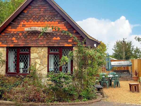 A traditional cottage-style building with a tiled roof and a sign reading "Tovey Lodge".