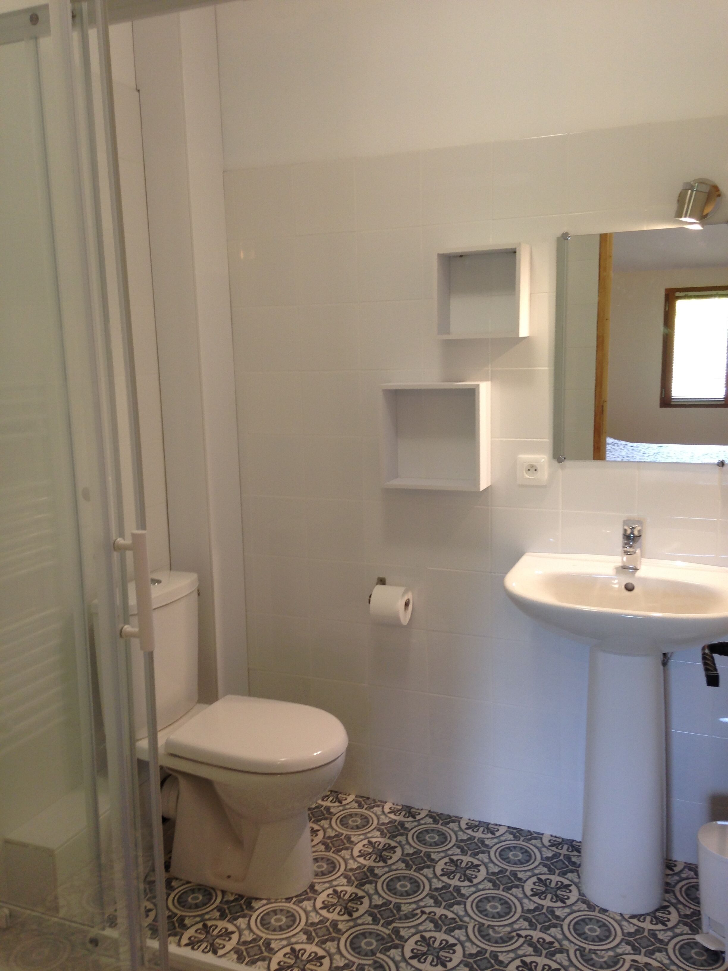 Ein Badezimmer mit Toilette, Waschbecken und Duschbereich.