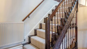 Una escalera con barandillas de madera y un radiador blanco.