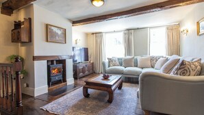 Una sala de estar con chimenea, sofá y televisión.