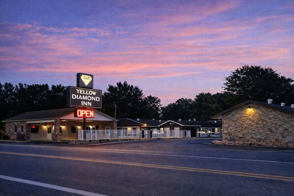 A Yellow Diamond Inn with a prominent sign, a welcoming entrance, and a stone building.