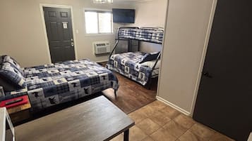 Un dormitorio con dos literas, un escritorio y una televisión.