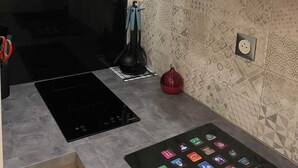 Una cocina moderna con estufa integrada, una tableta sobre la encimera y azulejos decorativos en la pared.