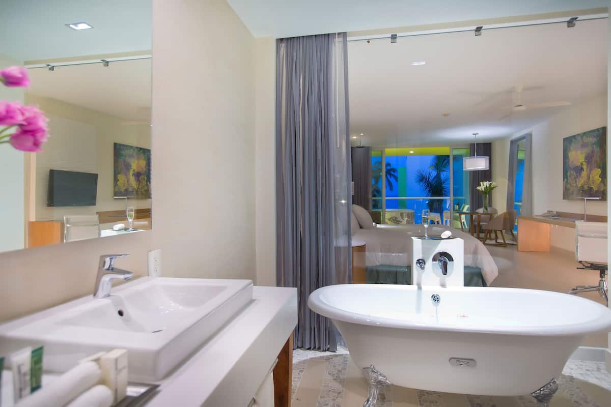 A modern bathroom with a freestanding bathtub, a large mirror, and a vanity with a sink.