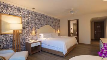 A bedroom with a bed, bedside tables, a lamp, a chair, and a mirror.