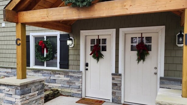 A building with a covered entrance, stone pillars, and two doors adorned with wreaths. - Discover Your Perfect Getaway! Beautiful Scenic Lakefront Condo (Montague)