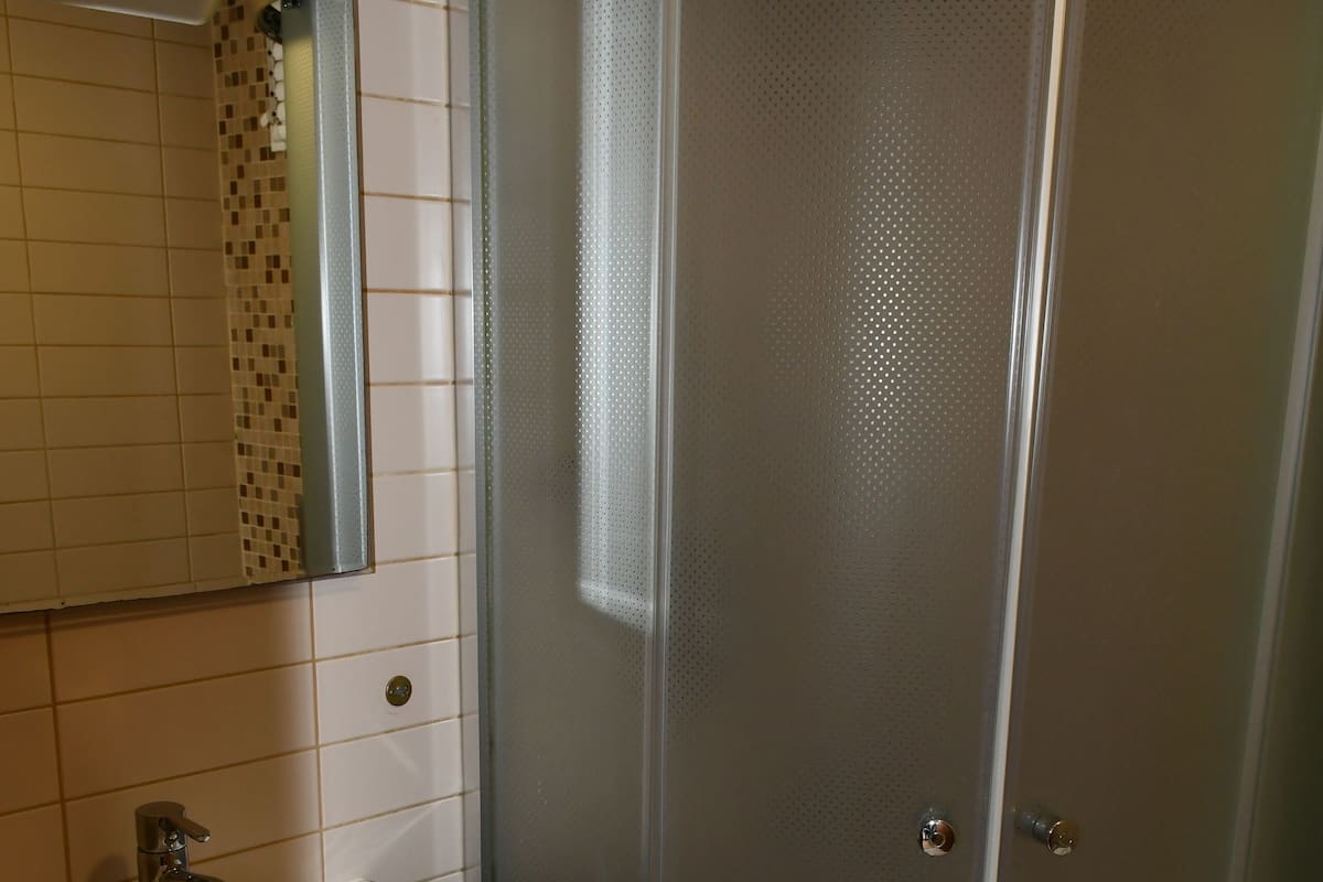 Een douche, een haardroger, pantoffels, handdoeken