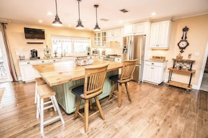 A spacious kitchen with a large island, wooden chairs, and a built-in bench. - Gran Kaymen May DISCOUNT Oasis: Pool&Spa/Mini-Golf/white sand beach/Pet Friendly (Apollo Beach)