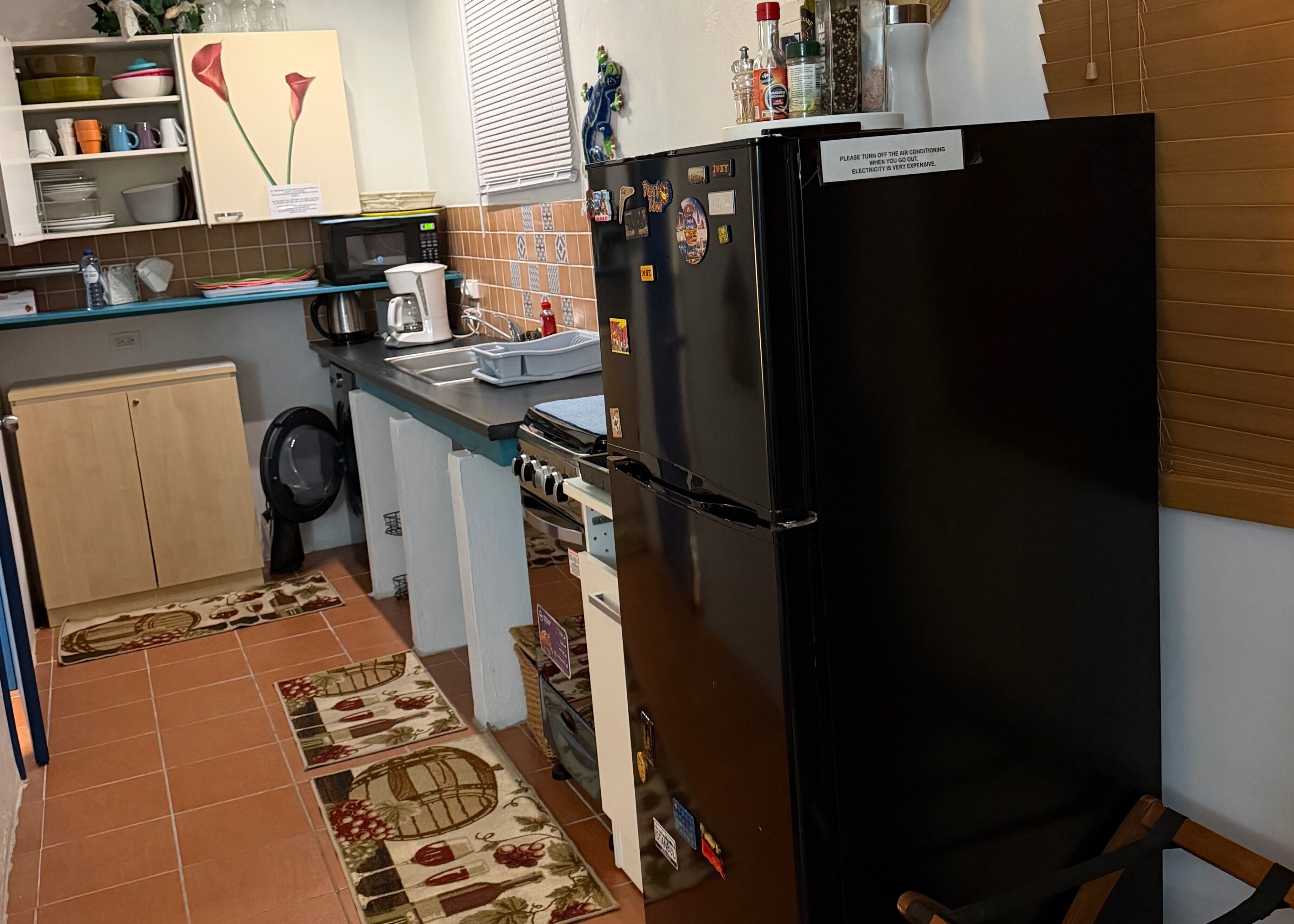 A compact kitchen with a refrigerator, microwave, and a coffee maker.