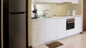 Een moderne keuken met witte kastjes, een inbouwoven en een roestvrijstalen koelkast.