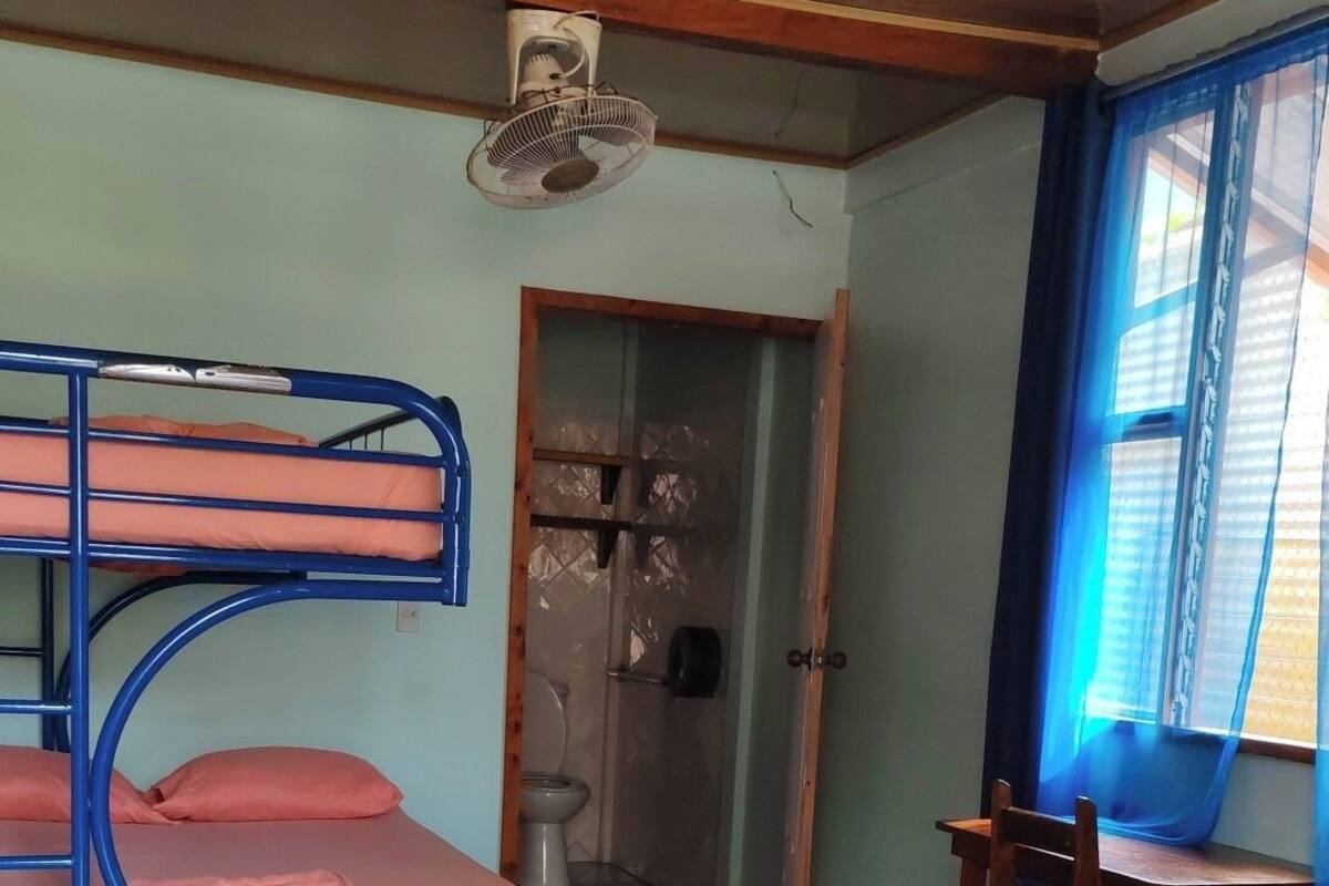 Una habitación con literas, un escritorio y una silla.