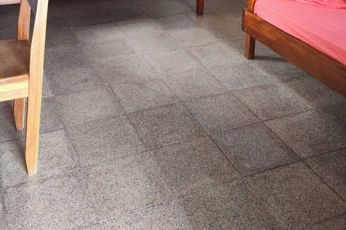 Una habitación con dos camas litera de madera, una mesita y un ventilador de techo.