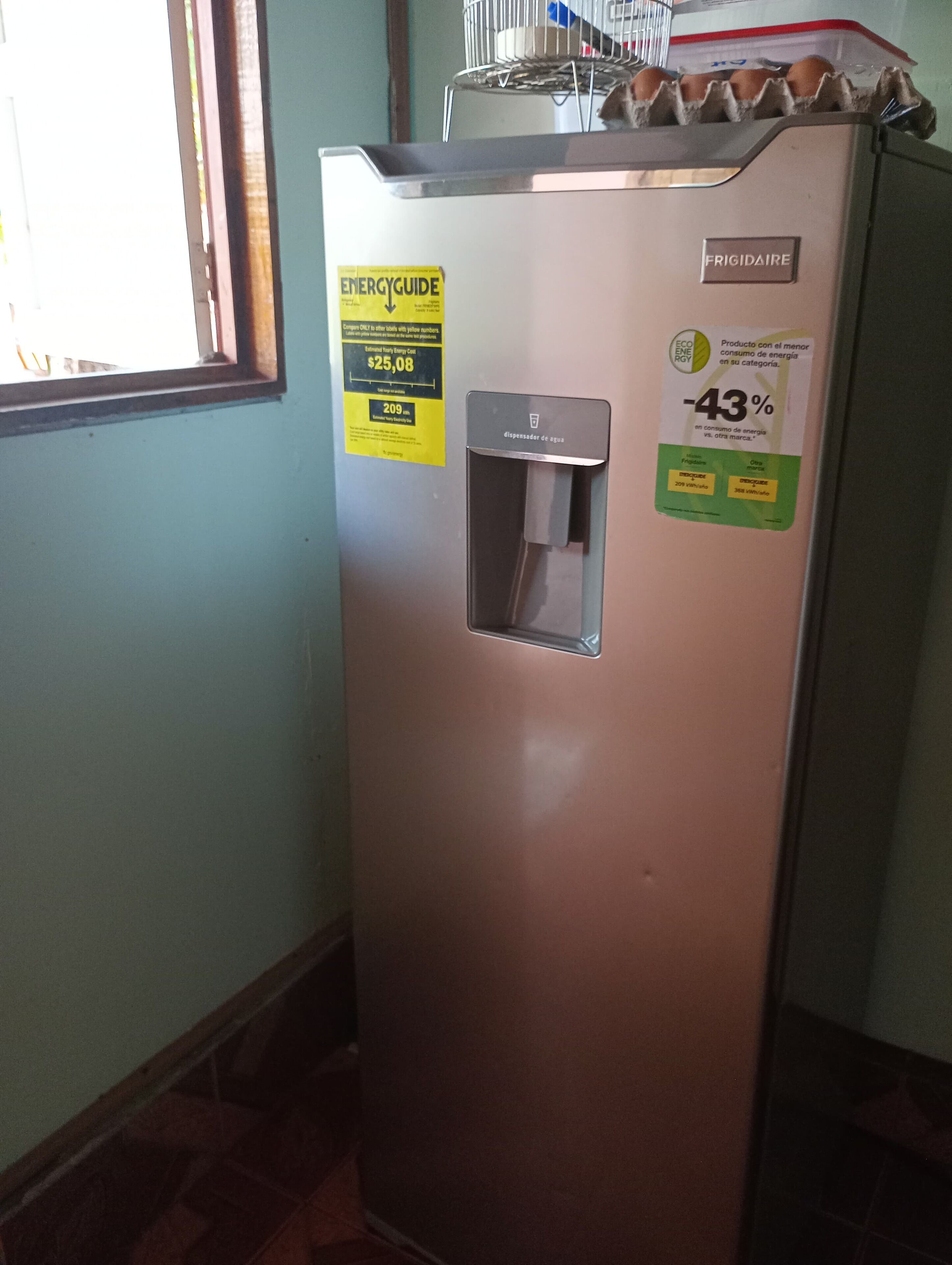 Máquina automática metálica com etiqueta de economia de energia, um dispensador de água e uma janela ao fundo.