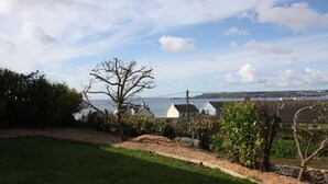 A coastal view with houses, a clear sky, and a body of water. - Amroth Holiday home with Sea Views (Narberth)