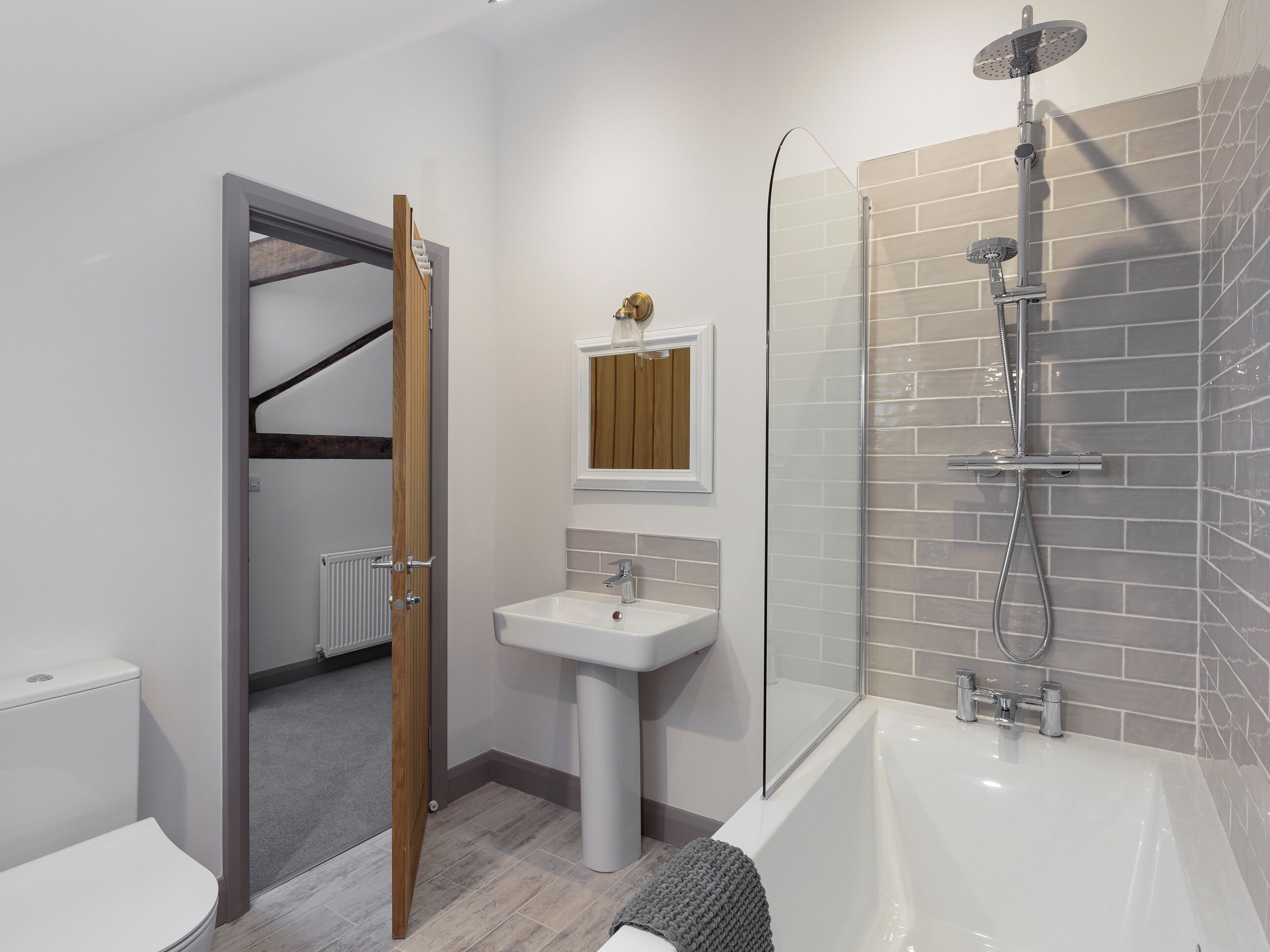 Un bagno moderno con doccia, toilette, lavandino e cabina doccia in vetro.