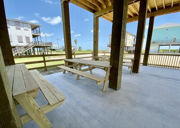 Enjoy a peaceful outdoor space with a picnic table and bench, surrounded by a wooden fence and offering a view of the surrounding area.