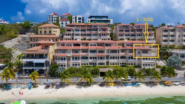 A beachfront hotel with multiple buildings, a sandy beach, and a clear view of the ocean. - GRANDE BAY RESORT - 3BR/ 2BA Directly on Cruz Bay (St John)