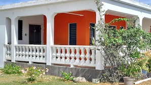 En toetages bygning med hvid facade og orange detaljer.